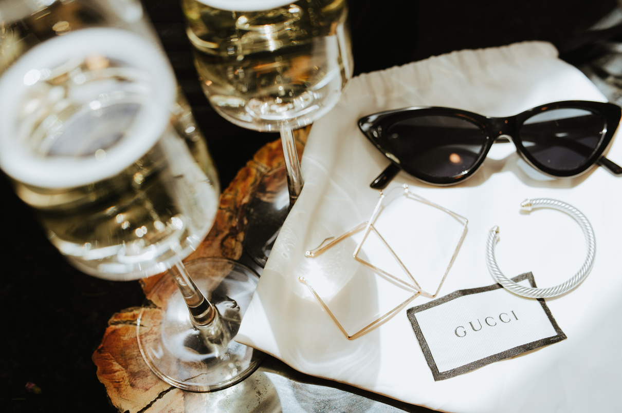 Black Sunglasses and Jewelries over a White Cloth Bag