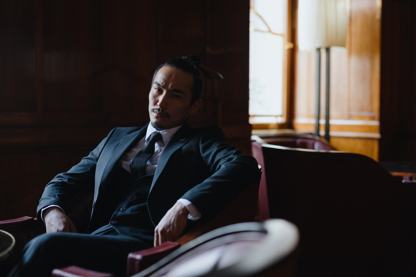 Man in Black Suit Sitting on Chair